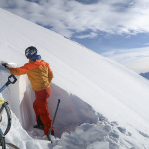 Bergführer gräbt ein Schneeprofil am Lawinenkurs.