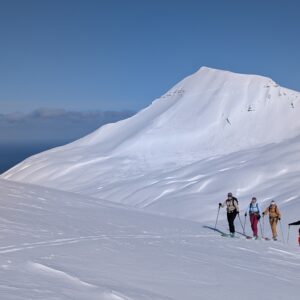 Skitourengruppe im Aufstieg zum Gipfel mit Meerblick